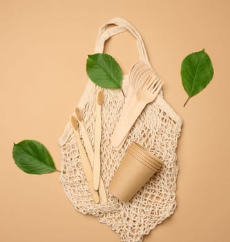 Cotton bag, wooden spoon, cups on a brown background. Waste recycling concept, zero waste