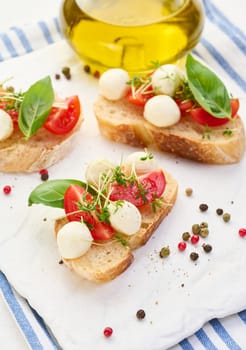 Round mozzarella, cherry tomatoes and microgreens on a piece of white bread, a healthy sandwich, top view