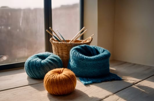 A cozy scene with wool yarn and a knitting basket by a sunny window. The image features blue and orange yarn balls in natural sunlight.