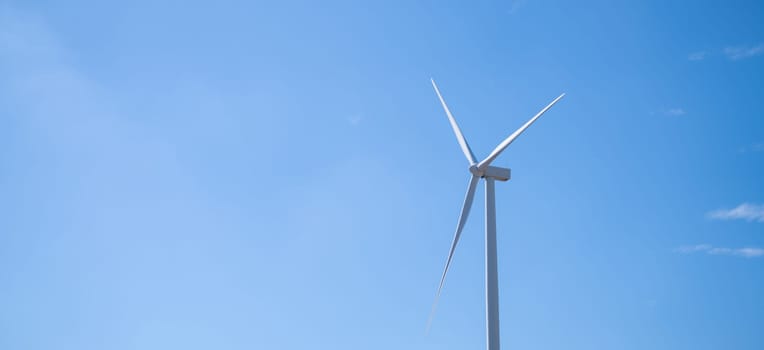 Wind energy. Wind power. Sustainable, renewable energy. Wind turbine in clear blue sky generate electricity. Sustainable resources. Sustainable development. Green technology for energy sustainability.