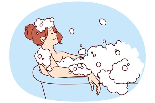Carefree woman relaxes lying in bath with foam and warm water after hard day at work or long walk. Concept of water spa treatments for relaxation and wellness or for skin and body care