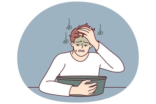 Young man feels nausea sitting near basin experiencing problem after being poisoned or suffering from hangover. Guy with symptoms of nausea and vomiting after alcohol party and unhealthy lifestyle