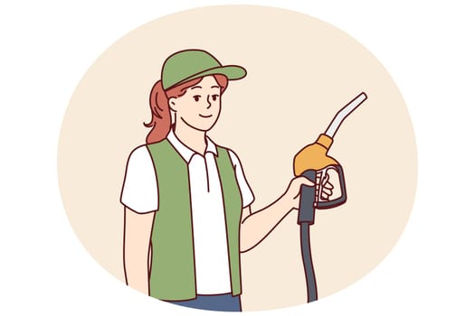 Woman serving customers at refueling station holding nozzles for refilling oil tank. Refueling station employee dressed in service uniform looks at screen with smile making career in fuel industry