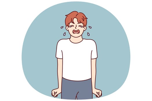Crying teenage boy stands clenching fists nervous after receiving reprimand from parents associated with poor grades at school. Teenage child crying due to psychological disorder or lack of toys