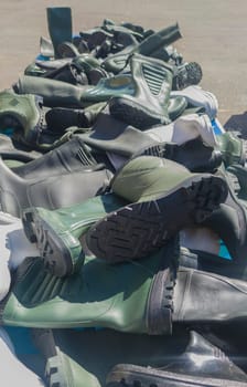 Loads of rubber boots on a street market stall. Selective focus