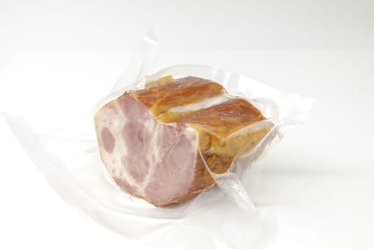 Smoked pork in vacuum packaging. Selective focus with shallow depth of field.