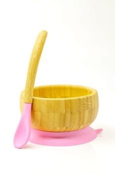 Bamboo baby bowl with spoon. Selective focus with shallow depth of field.
