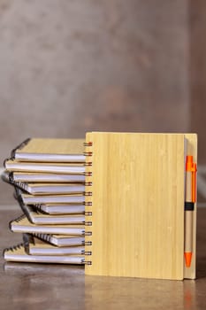 ECO notebook made of bamboo wood and recycled paper with pen. Selective focus with shallow depth of field.