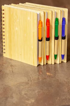 ECO notebook made of bamboo wood and recycled paper with pen. Selective focus with shallow depth of field.