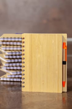 ECO notebook made of bamboo wood and recycled paper with pen. Selective focus with shallow depth of field.
