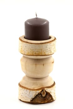 Wooden turned birch candlestick on a white background. Selective focus with shallow depth of field.