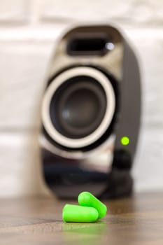 Green foam earplugs up close against the speaker