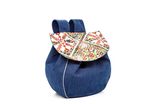 A small women's denim backpack with a cover of colorful embroidery motifs