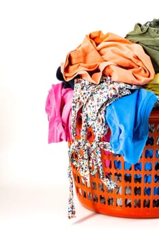 Red plastic laundry basket full of colorful clothes