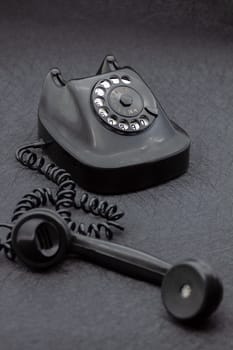 Vintage analog bakelite phone in black color. Selective focus with shallow depth of field.