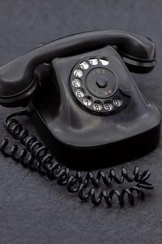 Vintage analog bakelite phone in black color. Selective focus with shallow depth of field.