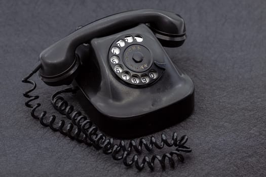 Vintage analog bakelite phone in black color. Selective focus with shallow depth of field.