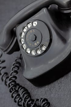 Vintage analog bakelite phone in black color. Selective focus with shallow depth of field.