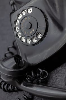 Vintage analog bakelite phone in black color. Selective focus with shallow depth of field.