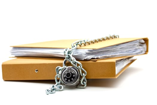 Cardboard document folders locked with chain and padlock. Selective focus with shallow depth of field.
