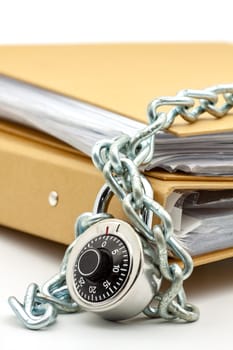 Cardboard document folders locked with chain and padlock. Selective focus with shallow depth of field.