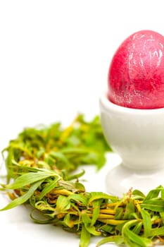 Traditionally painted red Easter egg and willow twig. Selective focus with shallow depth of field.