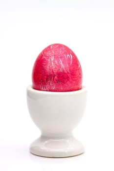 Traditionally painted red Easter egg in a porcelain cup.