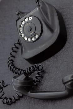 Vintage analog bakelite phone in black color. Selective focus with shallow depth of field.