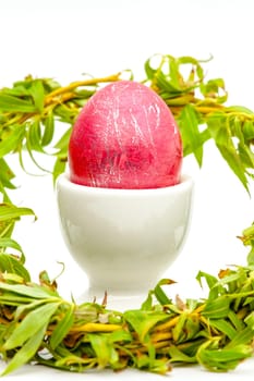 Traditionally painted red Easter egg and willow twig. Selective focus with shallow depth of field.