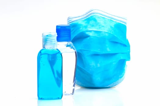 Bottles with antibacterial disinfectant and disposable mask. Selective focus with shallow depth of field.