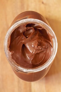 Chocolate spreading cream in glass jar viewed from above.Selective focus with shallow depth of field.