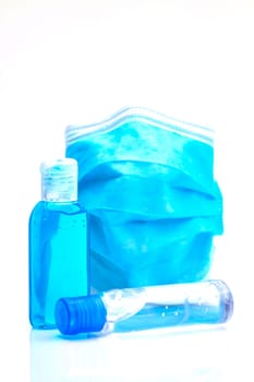 Bottles with antibacterial disinfectant and disposable mask. Selective focus with shallow depth of field.