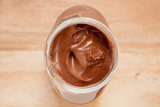Chocolate spreading cream in glass jar viewed from above.Selective focus with shallow depth of field.