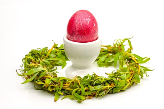 Traditionally painted red Easter egg and willow twig. Selective focus with shallow depth of field.