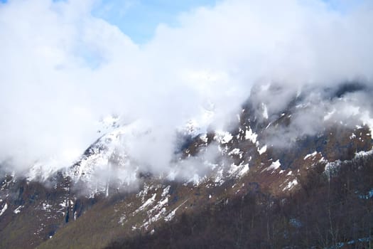 Norwegian landscape. The road leads through a mountain gorge that descends from the glacier. Rough nature in Scandinavia. Landscape photo from the north