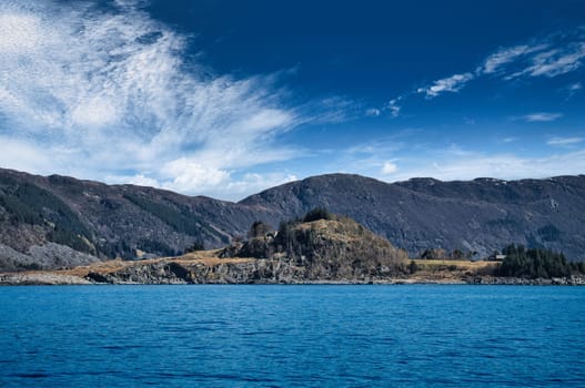 Fjord with mountains on horizon. Water glistens in the sun in Norway. Scandinavia landscape
