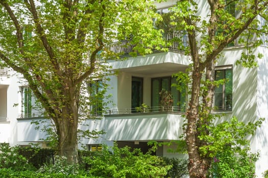 Modern, white residential building with balconies and trees in spring, Pöseldorf, Hamburg, Germany
