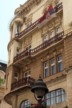 The elaborate facade of the Serbian Academy of Sciences and Art with a Serbian Flag on it, an example of Art Nouveau architecture in the city center of Belgrade, Serbia 2022