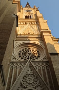 Closer look onto the elaborate facade of the bell, clock tower of the Name of Mary Church, an example of neo-gothic architecture in the city center, old town of Novi Sad, Serbia 2022