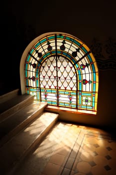 Light ist shining through a stained glass window onto the stairs in the stairwell, stairscase inside the Synagogue of Subotica, Serbia 2022