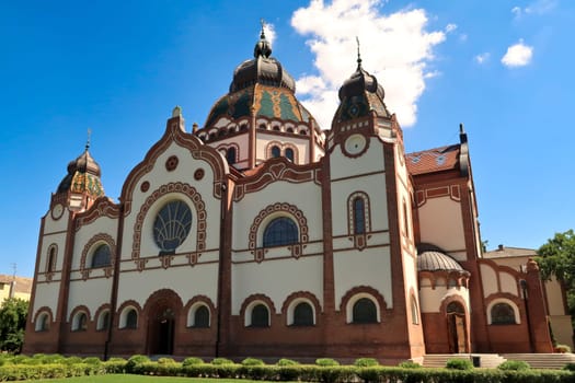 The entire facade around the side entrance of the Synagogue of Subotica on a sunny day with blue sky and white clouds, Subotica, Serbia 2022