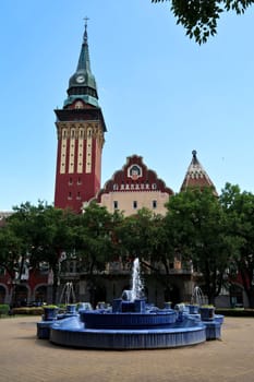 View from the main square, liberty square on the tower and facade of the city hall, town hall, the blue fountain in the foreground, Subotica, Serbia 2022