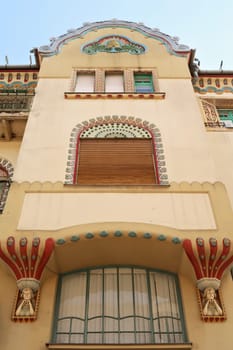 The facade of the Savings Bank Palace building, two stone carvings, reliefs, statues of girls, women bordering a window, an example of Art Nouveau architecture in the city center of Subotica, Serbia 2022
