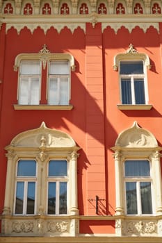 Windows on the red facade of the Vojnic Palace building in the city center of Subotica, Serbia 2022