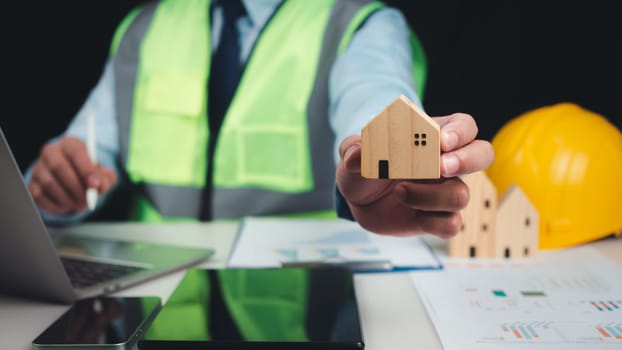 Architect or engineer using tablet to work on table, Construction planning, Structural calculation, Structural design, Project presentation plan, Construction cost planning, Cost calculation.
