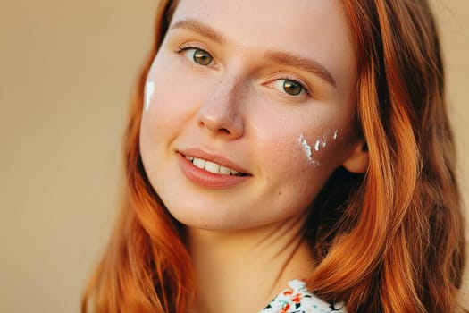 Close-up portrait of a young red-haired teenage girl or young woman with cream smears on her skin. Concept of care for young skin