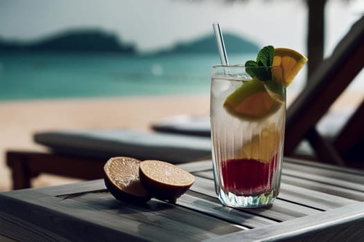 Summer beverage with berries and lemon - served on a natural wood table against a seascape