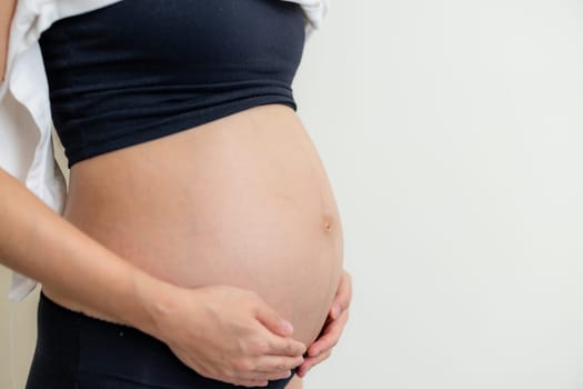 Pregnant woman hold her belly close up