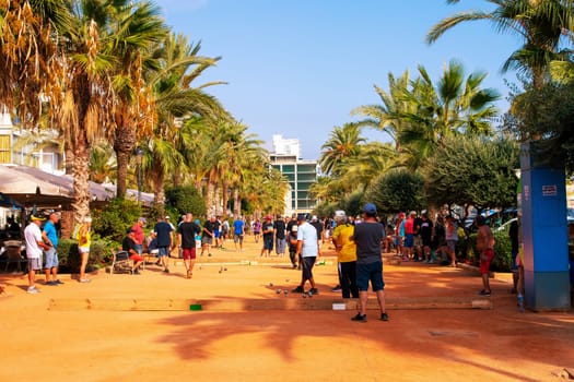 Lloret de Mar, Catalonia, Spain, 01 October 2019: Tourists play boccia on the beach promenade in Lloret de Mar on the Costa Brava on the Mediterranean.