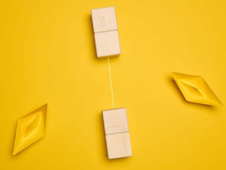 Two yellow paper boats and a barrier between them. Concept of searching for compromises, top view